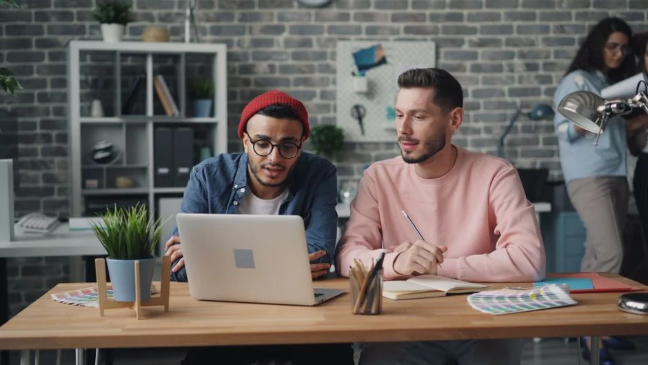 Deux écrans sur un bureau, mettant en avant du web design dans un environnement de bureau contemporain.