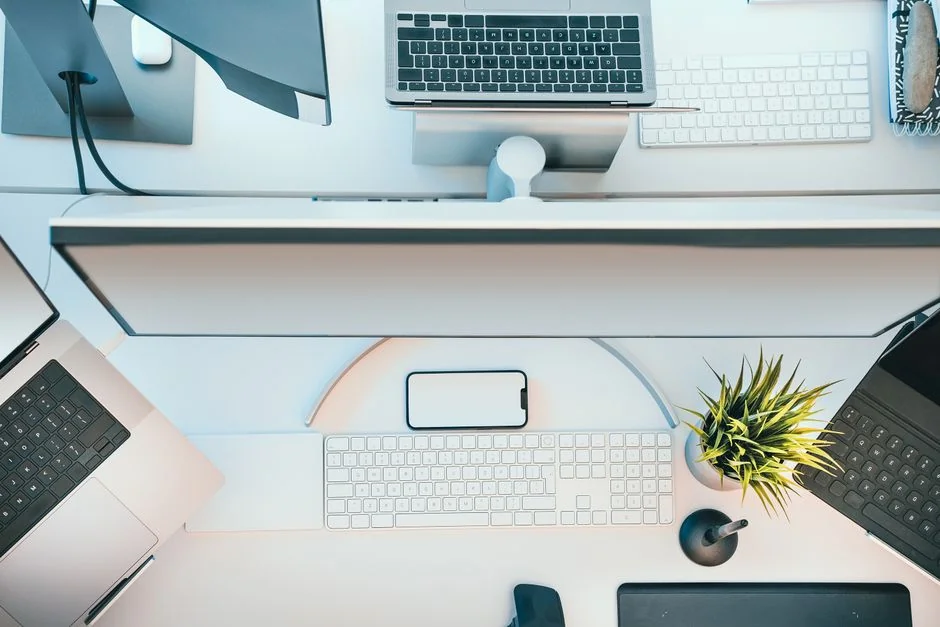 Un espace de travail moderne présentant un ordinateur portable, une tablette et des smartphones, parfait pour un usage tech et freelance.